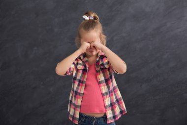 Ağlama ve elleriyle gözlerini kapsayan küçük kız