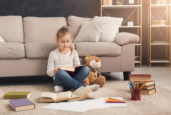 Little girl with book and her favorite toy at home — Stock Photo, Image