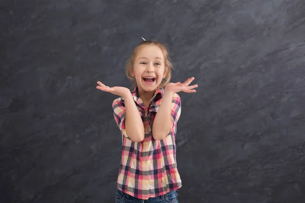 Menina feliz se divertindo no fundo cinza — Fotografia de Stock