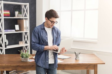 Genç işadamı dizüstü kullanarak konsantre