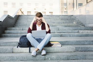 Dizüstü bilgisayar açık havada üzerinde çalışma merdivenlerde oturan Desparate öğrenci