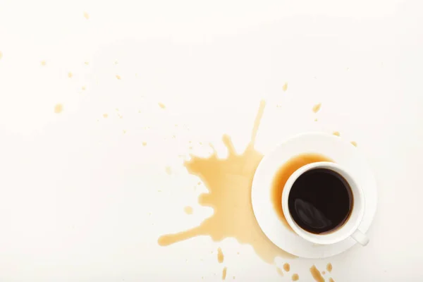 Coffee cup and spilt espresso on white background — Stock Photo, Image