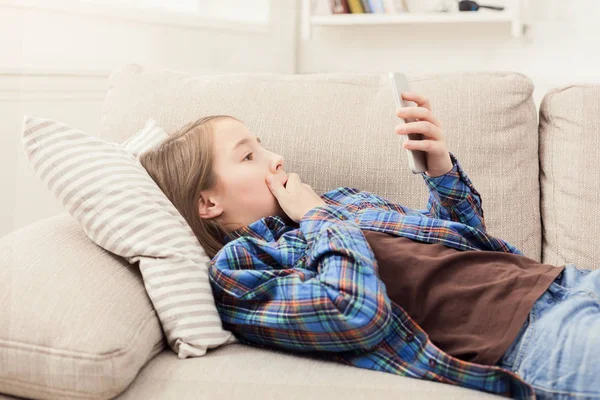 Young shocked girl with smartphone at home — Stock Photo, Image