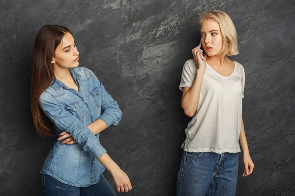 Chica escuchando a su novia hablar por teléfono móvil — Foto de Stock