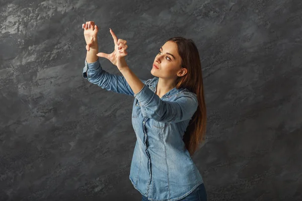 Pensive girl making gesture at black background — Stock Photo, Image