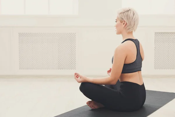 Молодая женщина в классе йоги, расслабиться медитации позы — стоковое фото