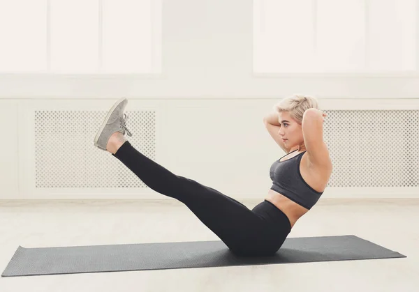 Frau trainiert Yoga in Boot-Pose. — Stockfoto