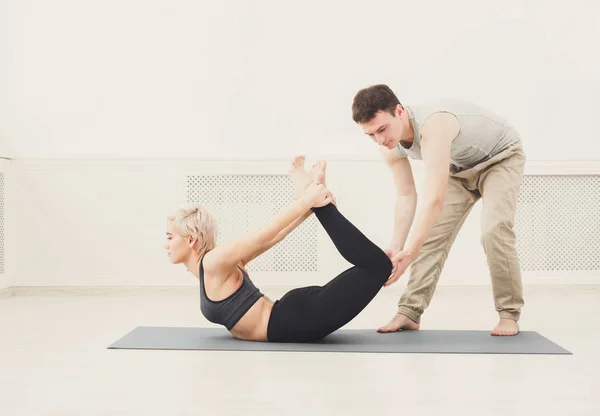 Jovem com instrutor de ioga no clube de fitness — Fotografia de Stock