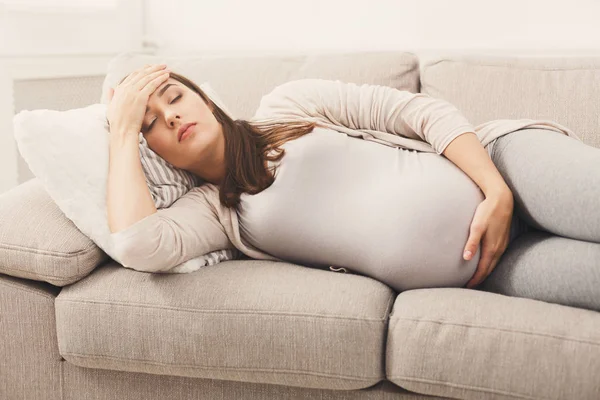 ソファーで横になっている頭痛で若い妊婦 — ストック写真