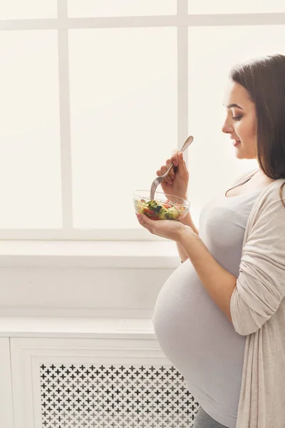 Jovem grávida comendo salada verde fresca — Fotografia de Stock