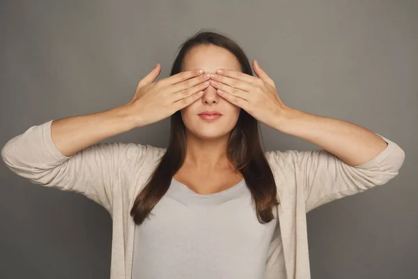 Scared woman covering eyes with hands, see no evil
