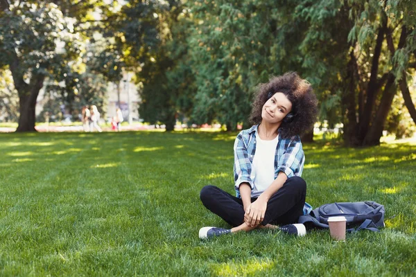 Ung kvinna Lyssna på musik på gräs utomhus — Stockfoto