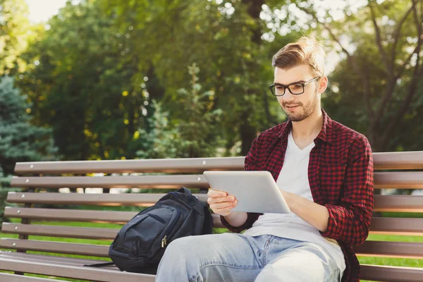 Hombre sorprendido en el parque con la tableta al aire libre — Foto de Stock