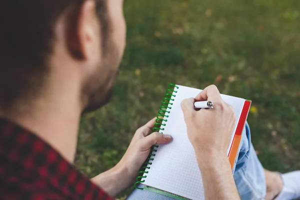 Manos masculinas con cuaderno de primer plano, sobre hombro tiro al aire libre — Foto de Stock