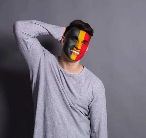 A Belgium lobogója alatt az arcán festett fiatalember — Stock Fotó