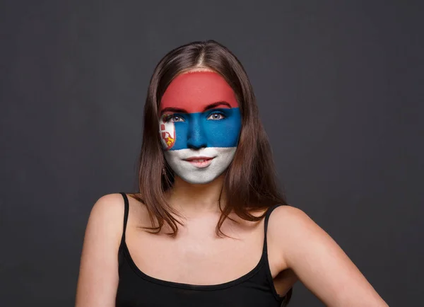 Молода жінка з прапор Сербії, намальовані на її обличчі — стокове фото