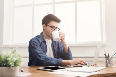 Genç iş adamı dizüstü bilgisayarla çalışıyor