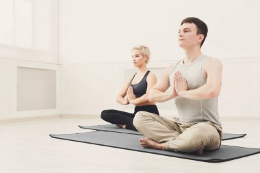 Genç çift padmasana içinde oturan yoga uygulamak