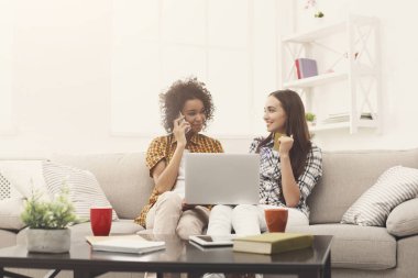 Kredi kartı ve dizüstü bilgisayar ile iki kadın online