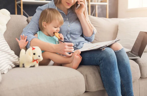 Jeune mère travaillant et passant du temps avec bébé — Photo