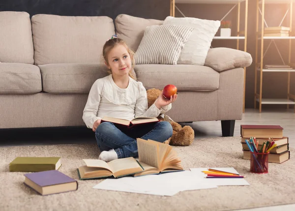Malá holčička s knihou a apple doma — Stock fotografie