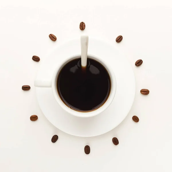 Black coffee cup and roasted beans forming clock dial isolated on white — Stock Photo, Image