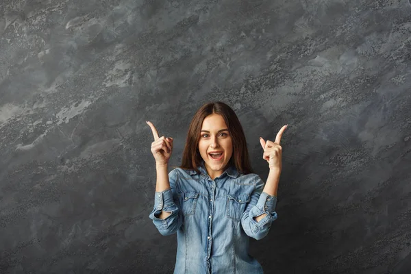 Jovem menina feliz apontando para cima — Fotografia de Stock