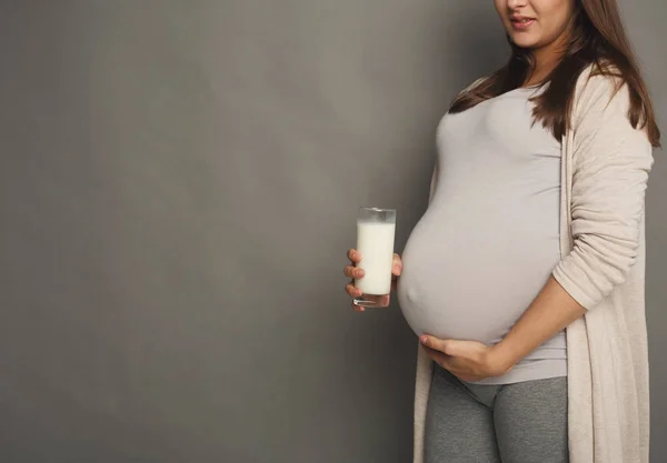 Вагітна жінка зі склянкою молока копіює простір — стокове фото