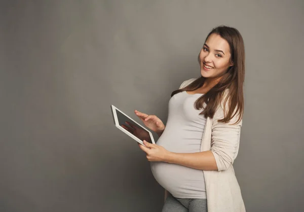 Mujer embarazada feliz usando tableta digital — Foto de Stock