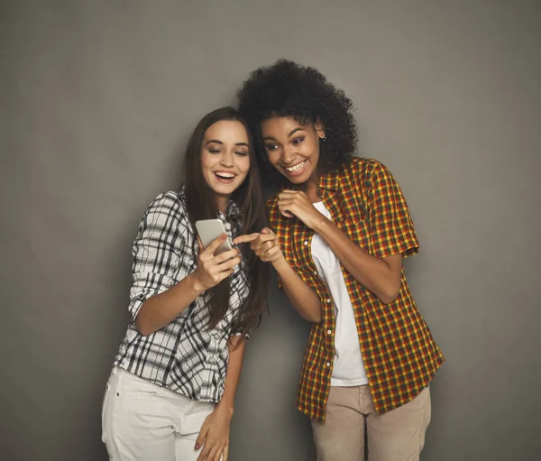 Deux amies heureuses utilisant un smartphone — Photo