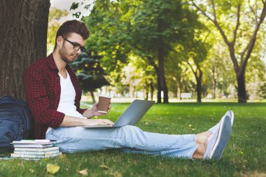 Laptop ve kahve açık havada olan yakışıklı adam