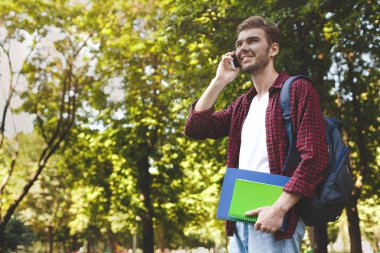 Mutlu öğrenci parkta smartphone cep telefonu ile konuşmak