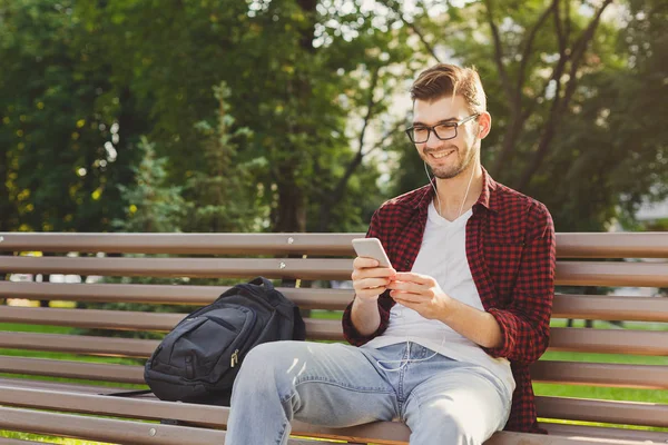 Jovem feliz usando smartphone ao ar livre — Fotografia de Stock