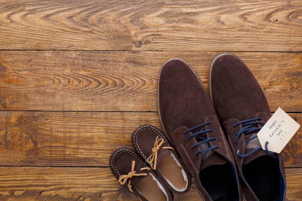 Scarpe da uomo e bambino su sfondo in legno rustico — Foto Stock