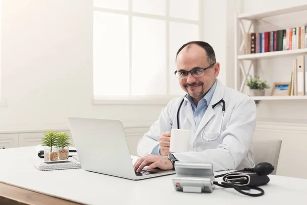 Портрет врача в очках, сидящего за столом — стоковое фото