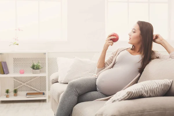 Pregnant woman eating apple at home copy space — Stock Photo, Image