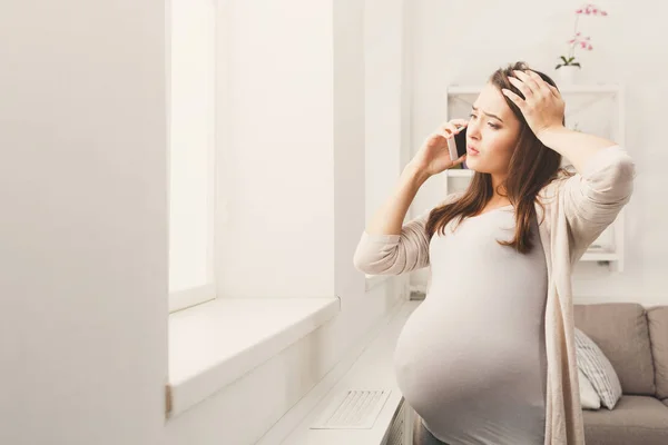 Inquiète femme enceinte parler sur l'espace de copie de téléphone — Photo