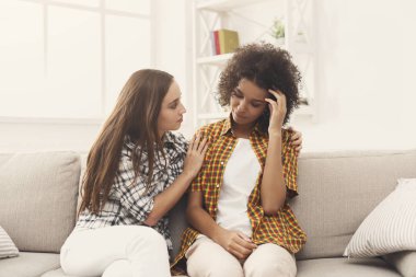 İki kadın evde sorunlar hakkında konuşuyor.