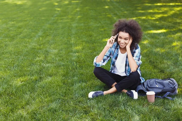 Ung kvinna prata telefon och ler utomhus — Stockfoto
