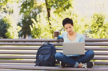 Shorthaired kadın serbest meslek sahibi dışında bir dizüstü bilgisayar üzerinde çalışan