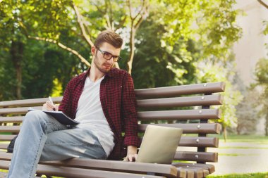 Laptop ve defter açık havada yoğun öğrenci