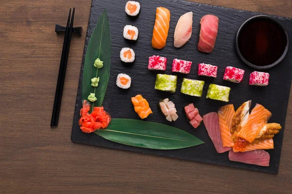 Sada různé sushi, maki a rohlíky na rustikální dřevěné pozadí — Stock fotografie
