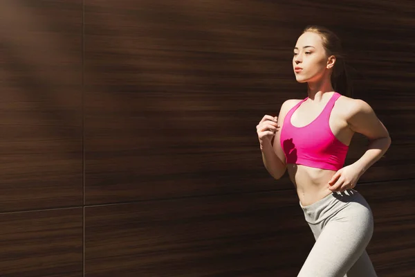 Young woman jogging in city copy space — Stock Photo, Image