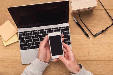 Smartphone vintage ahşap masa üzerinde tutan adam.