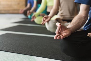 Genç kadın ve erkek yoga sınıfındaki rahatla meditasyon poz