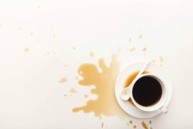 Kahve fincanı ve beyaz zemin üzerine dökülen espresso