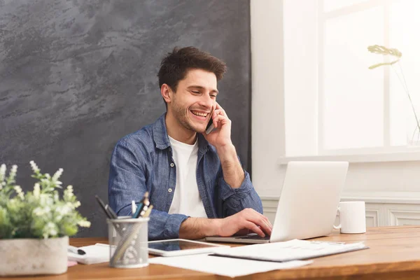 Joven hombre de negocios tiene charla móvil en la oficina moderna — Foto de Stock