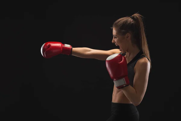 Visão lateral da jovem mulher emocional com luvas de boxe — Fotografia de Stock