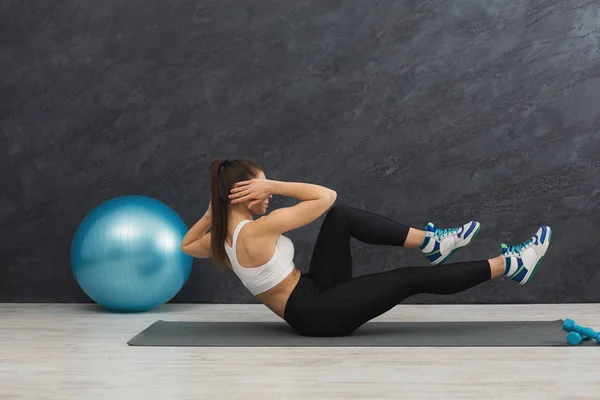 Fitness woman working on her abs indoors — Stock Photo, Image