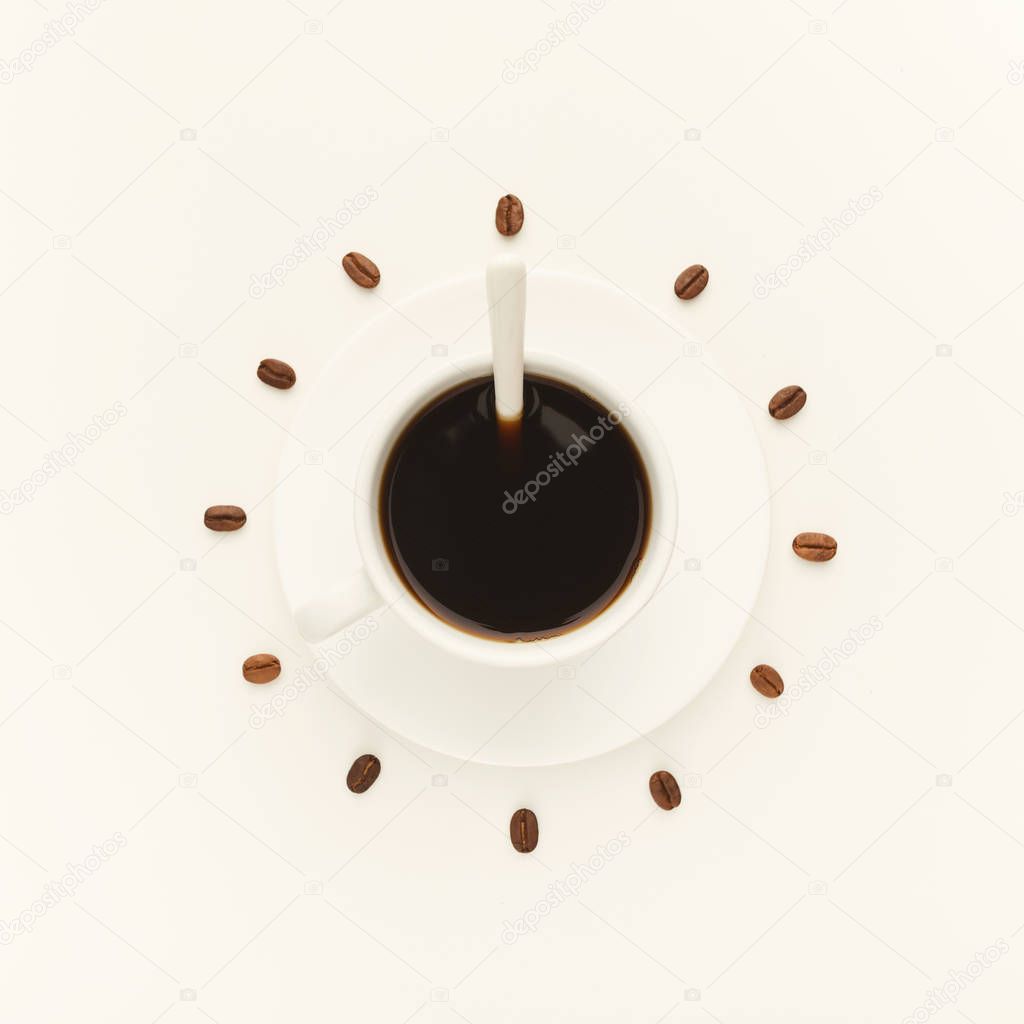 Black coffee cup and roasted beans forming clock dial isolated o